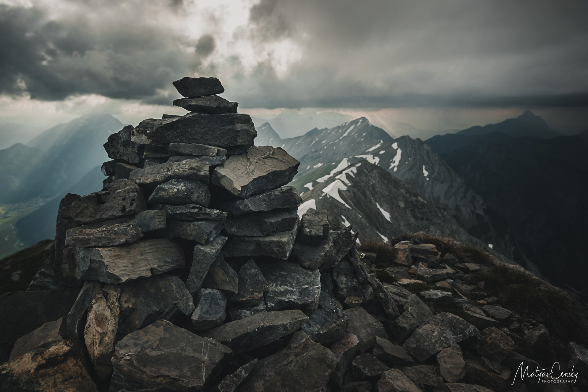 Photo of the very top of Ups Spitze in Austria with cloudy sunset in the background.