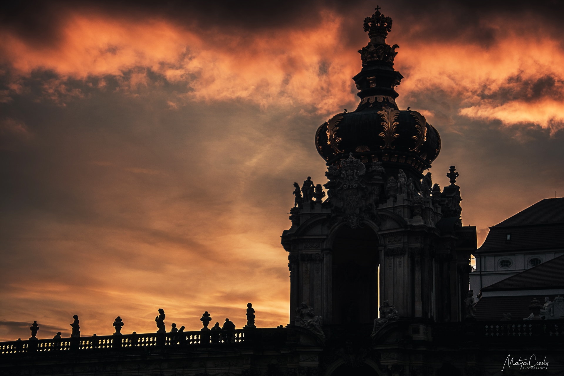 Photo of dressden decorative rooftops as sillouette with orange, cloudy sunset in the  background.