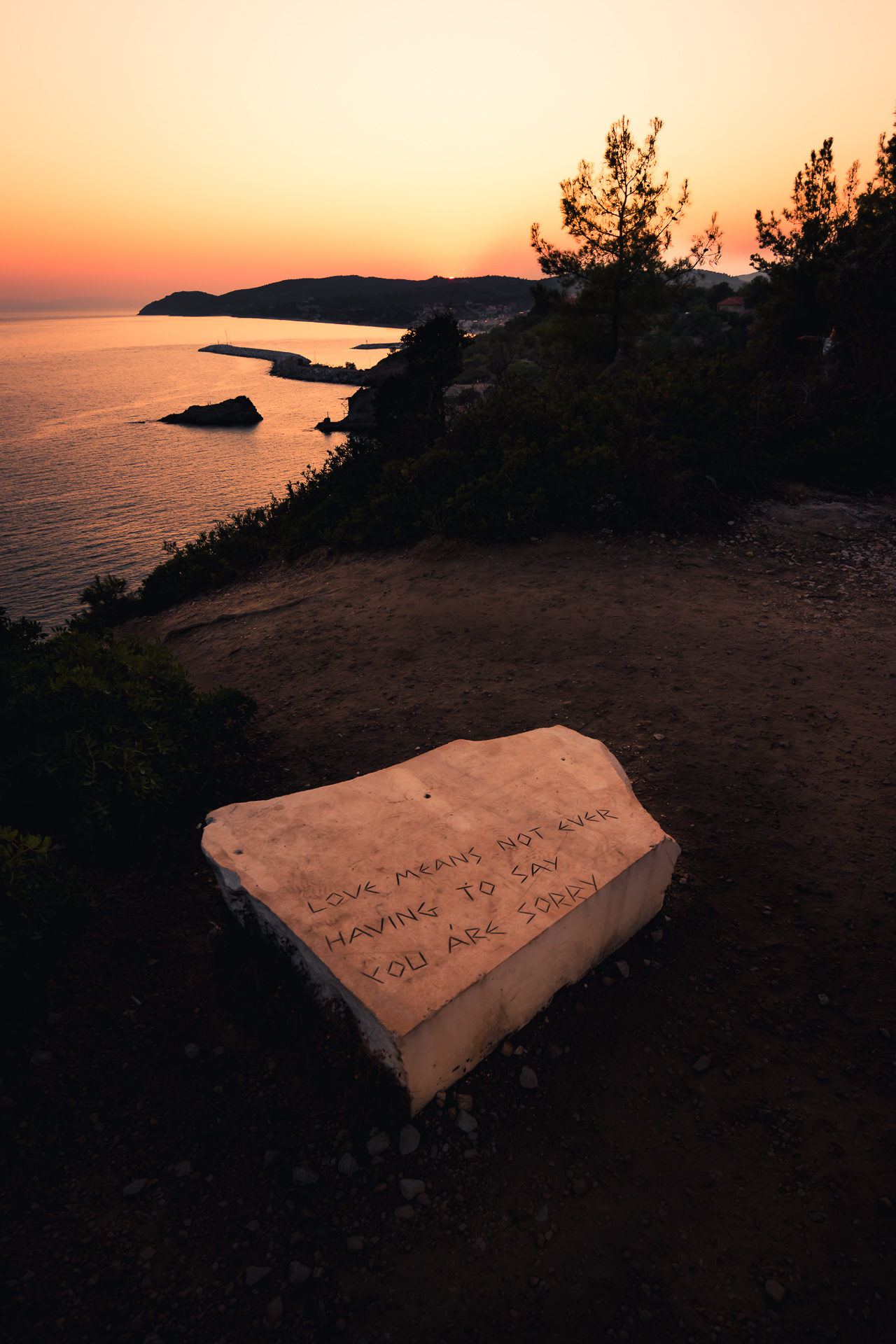 Photo of a white marble stone with engraving with a sunset in Thassos, Greece.