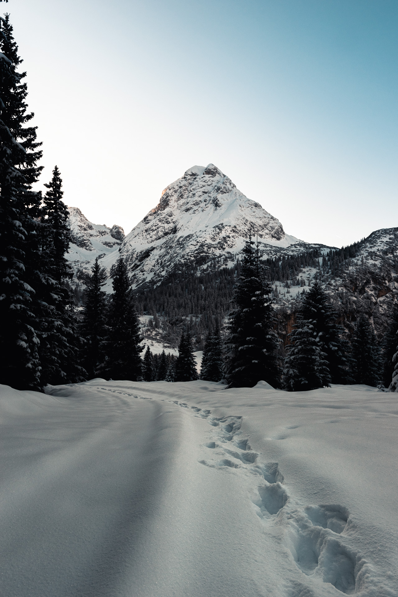 Photo of a winter scene with Sonnespitze in the back ground and footprints in the snow, Austria.