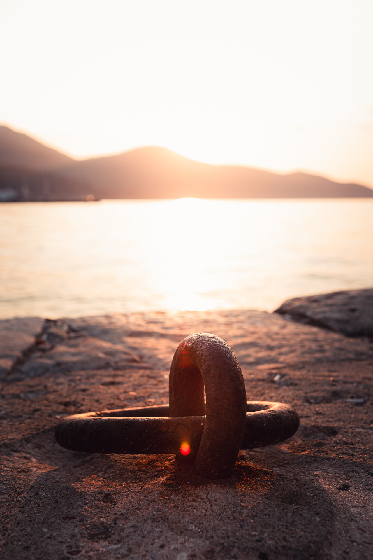Photo of a sunset with an anchor ring in Greece.