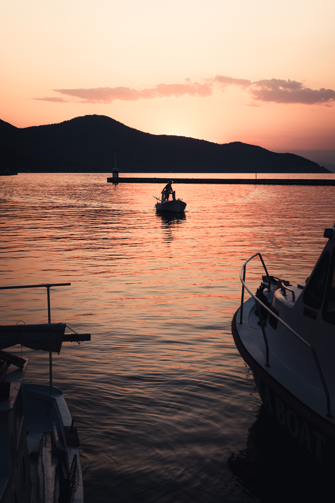 Photo of a boat coming back in a sunset at Thassos, Greece.